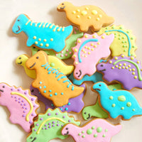 A pile of colorfully decorated dinosaur cookies for a fun holiday baking experience.