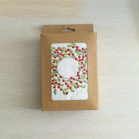 Holiday cotton towel showcasing a detailed embroidered Christmas wreath, ideal for home decor or gifting