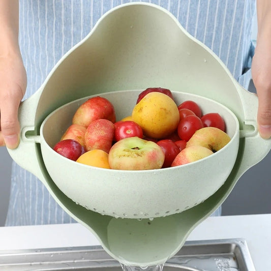 A double-deck colander being used for washing fruit and tomatoes