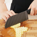 A person cutting potatoes using crinkle cutter for fries