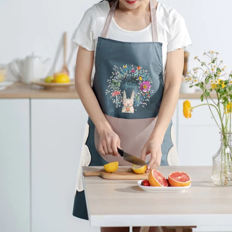 A woman cutting fruit in a blue pinafore