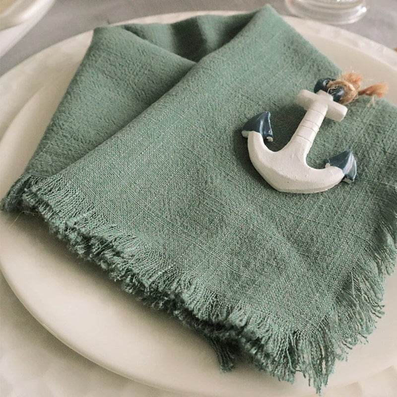 A green cotton tissue folded on a dinner table