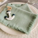 A light green fabric napkin folded on a plate