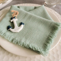 A light green fabric napkin folded on a plate