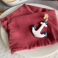 A red cotton napkin folded on a bread plate