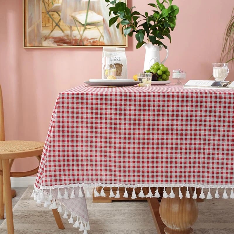 A tablecloth with tassels featuring red and white squares print gives a classical look to your dining table.