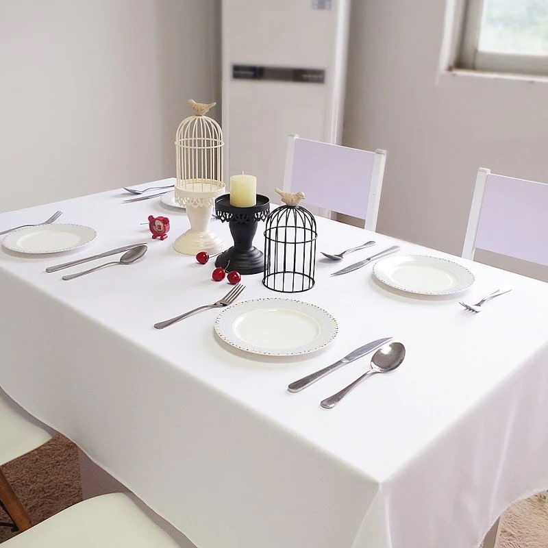 A set table with an elegant white tablecloth, perfectly suited for all occasions.