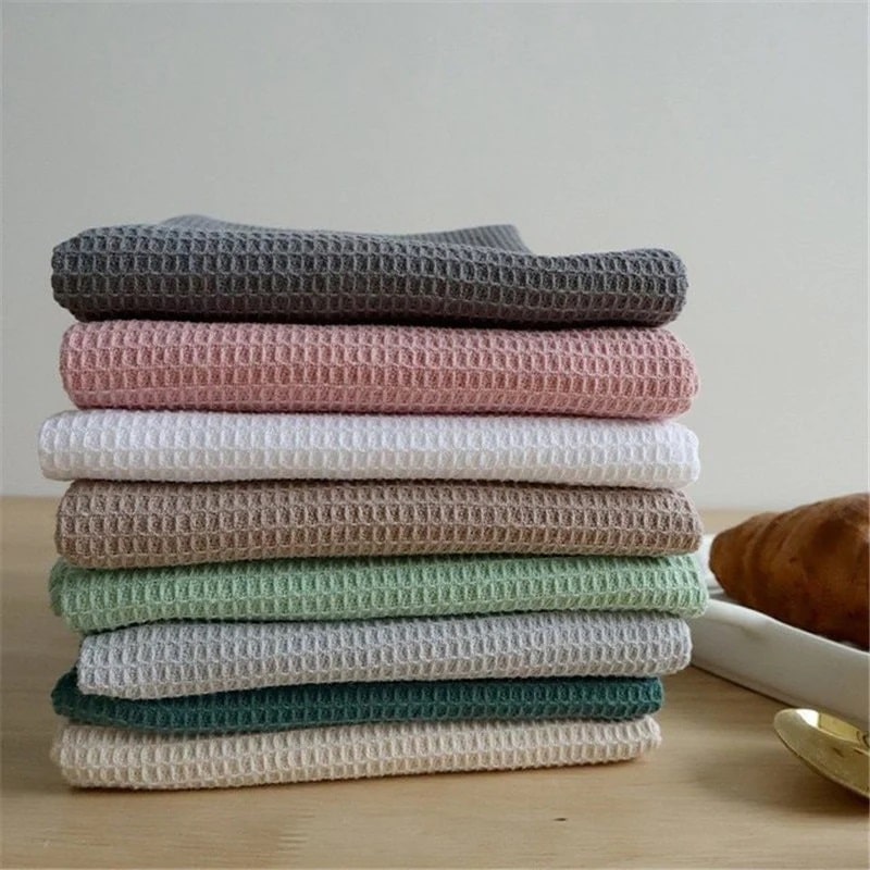 Waffle towels in different colors folded on the kitchen counter