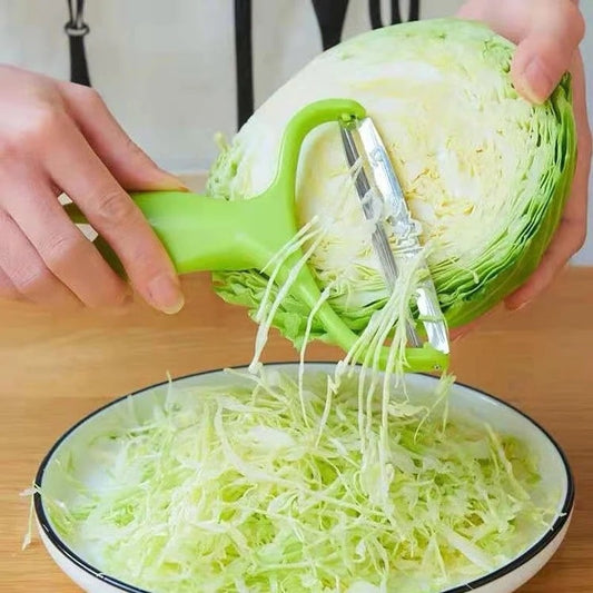 Vegetable and fruit peeler. Y-shaped peeler shredding cabbage into nice thin shred.